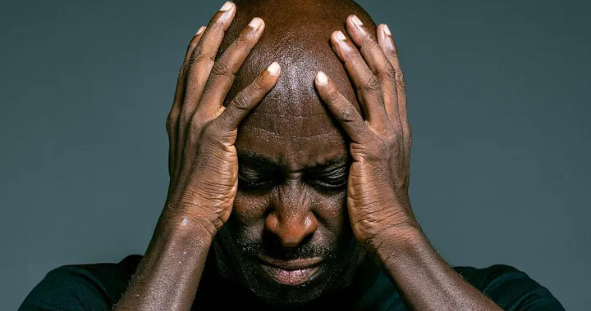 Man holding his head in pain from a migraine, symbolizing chiropractic care benefits